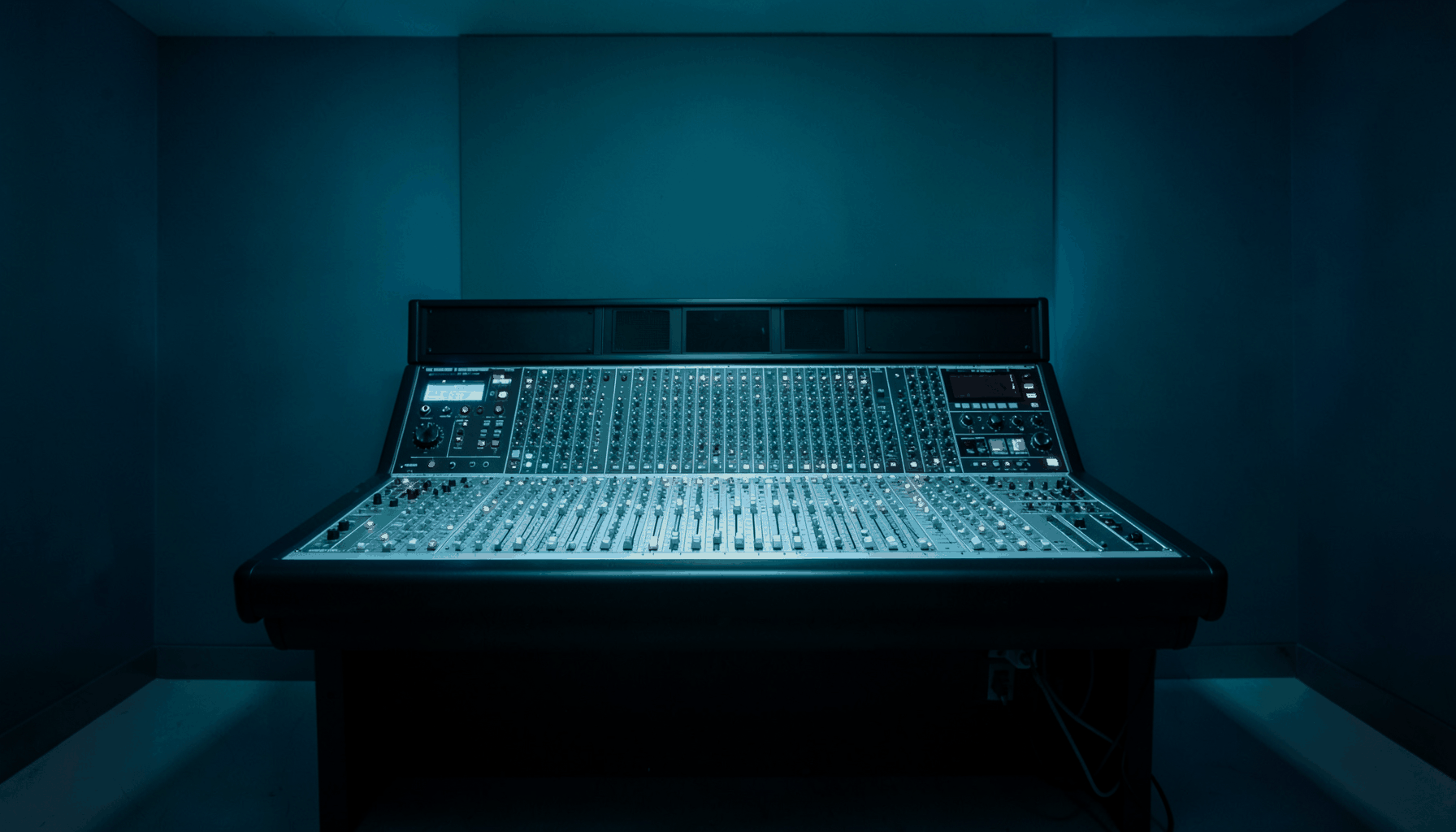 A clean symmetrical photograph of a music studio mixing desk viewed straight on, deep teal and navy tones with soft blue