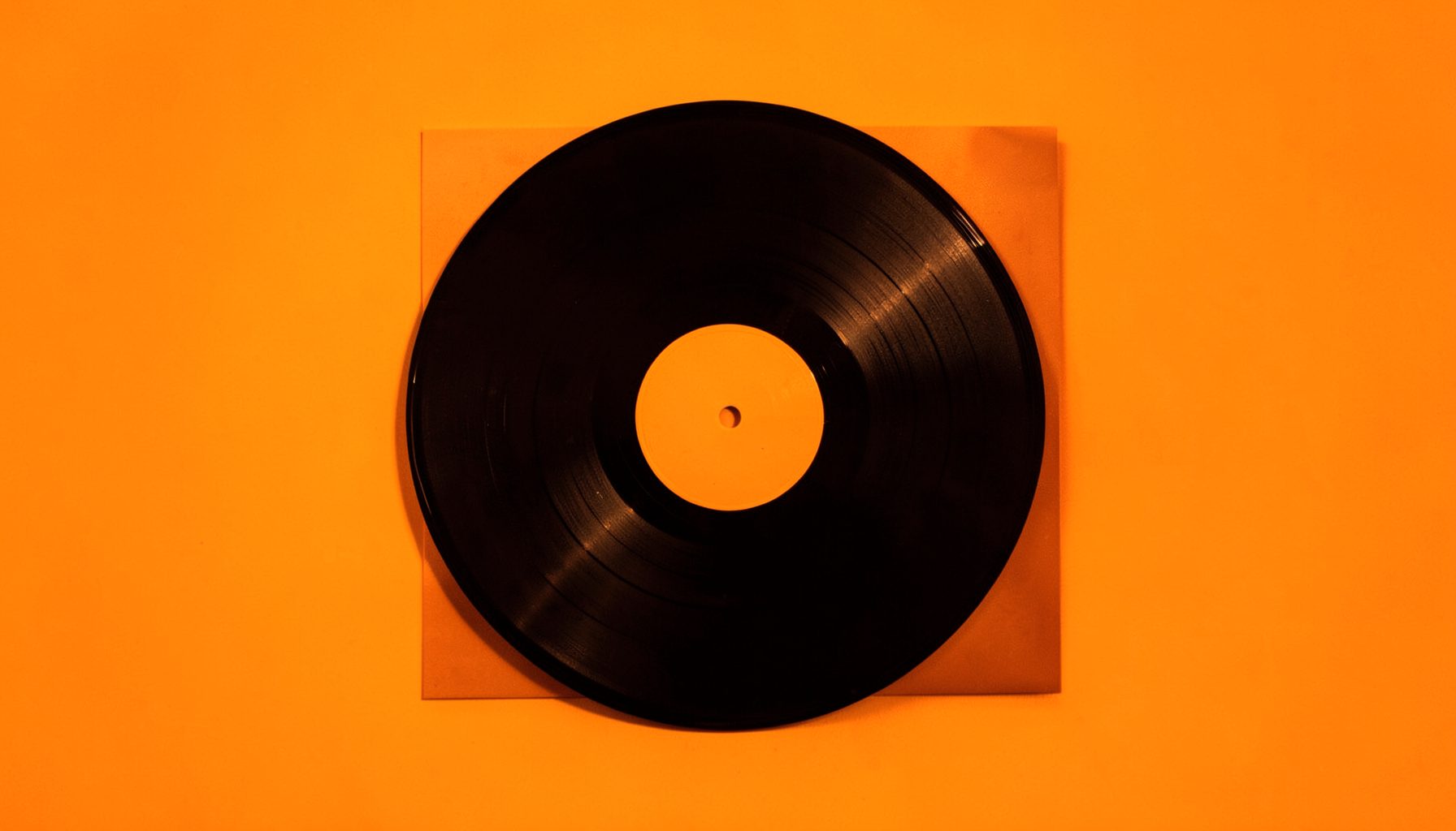 Small square photograph of a vinyl record close up in warm orange light, calm nostalgic mood